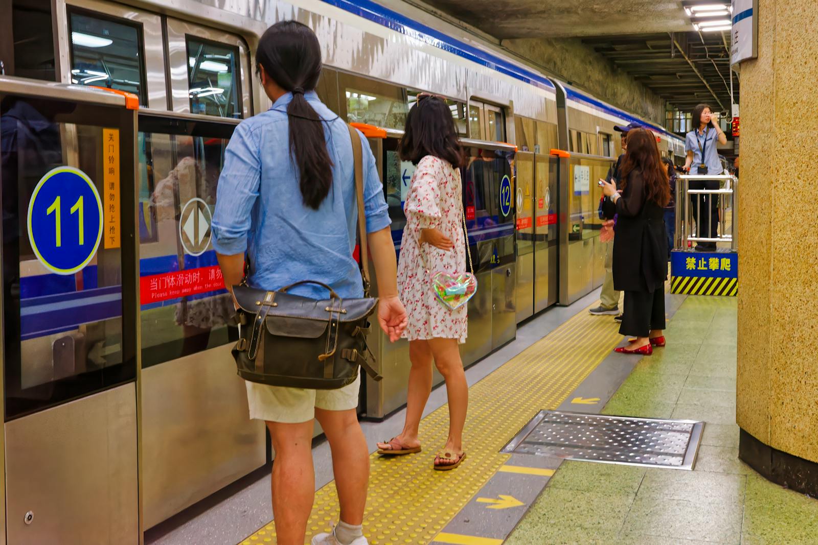 A Beijing Subway train at a platform with bilingual Chinese-English signage
