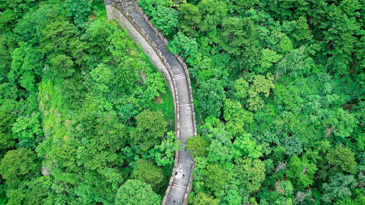 The restored Ming-era Great Wall at Mutianyu with watchtowers along a forested ridge
